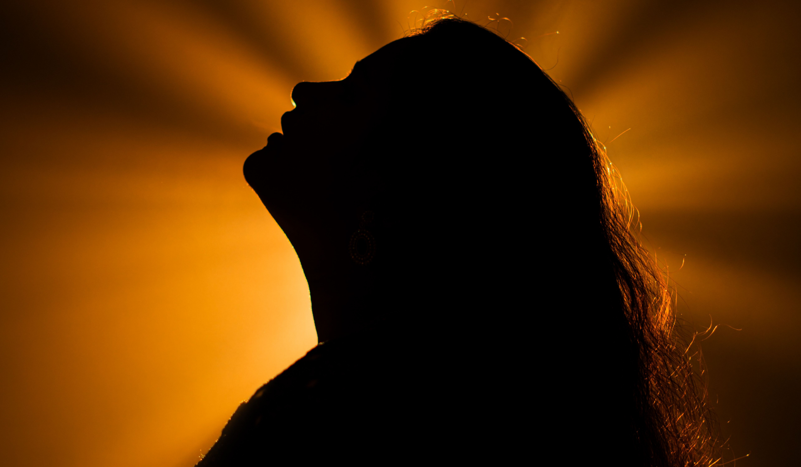 Woman with light shining on face symbolizing the process of leaving Christianity and rebuilding a spiritual practice.