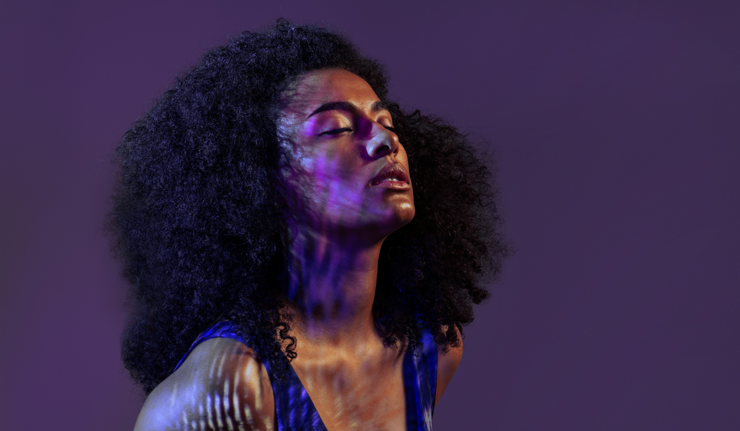 High achieving woman feeling empty stands in light, searching for meaning beyond success.